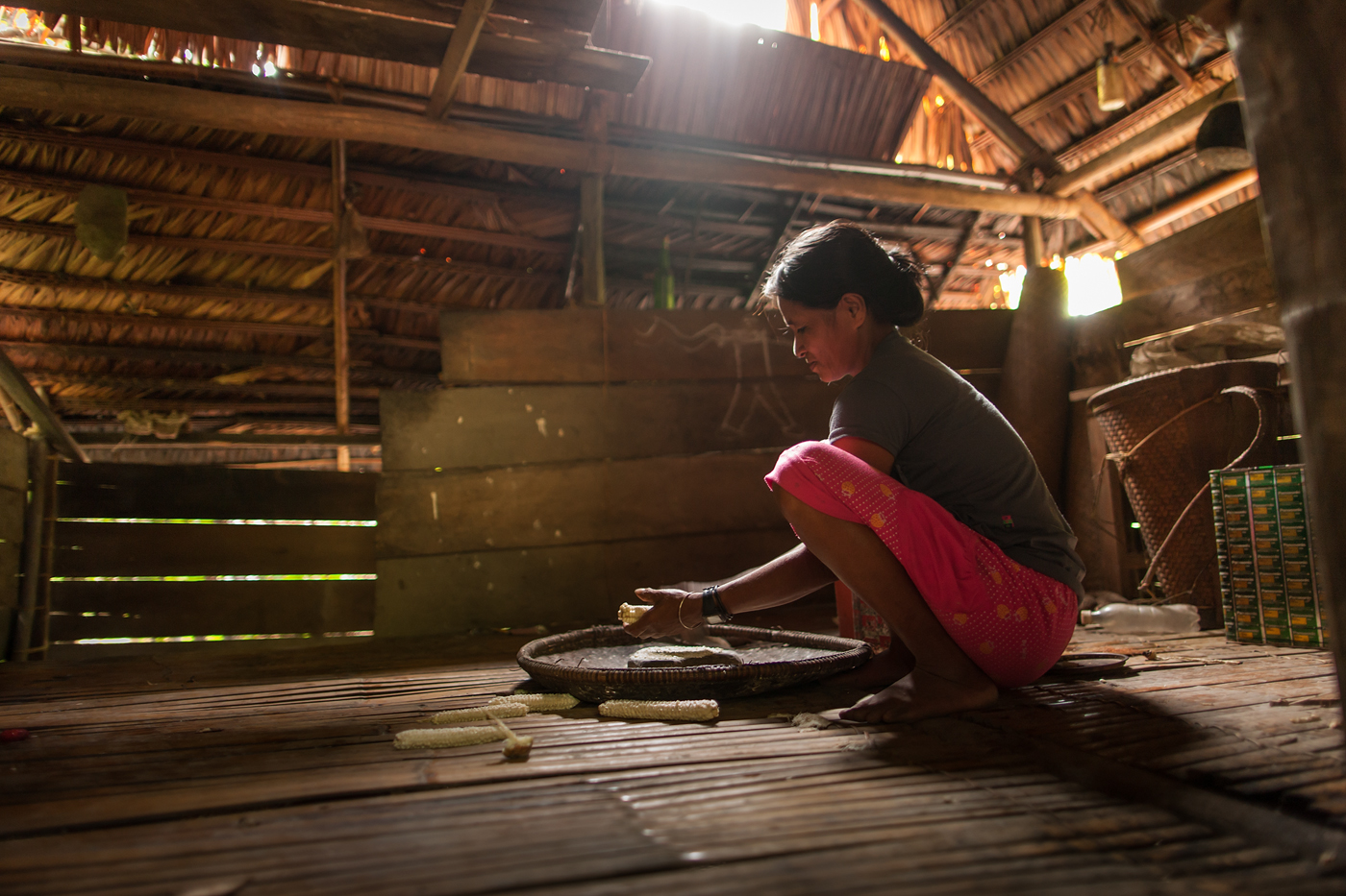 woman preparing food in a rustic hut