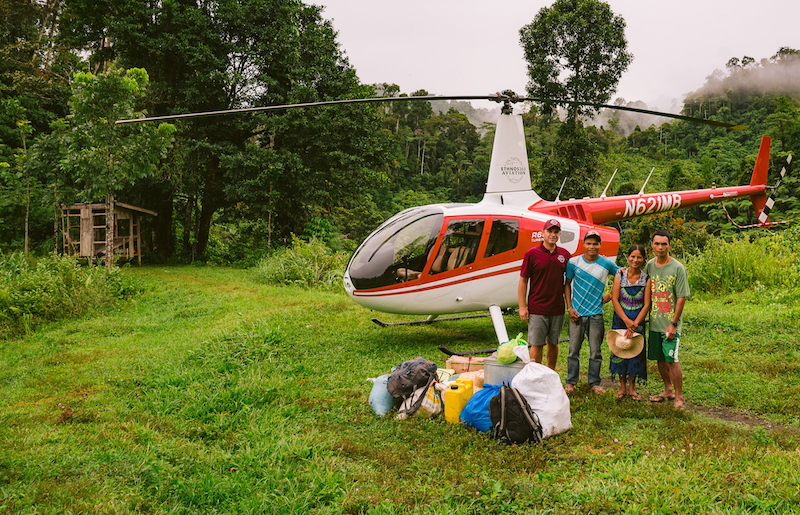 pilot and 3 national missionaries standing in front of helicopter