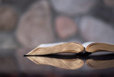 open Bible on a reflective table