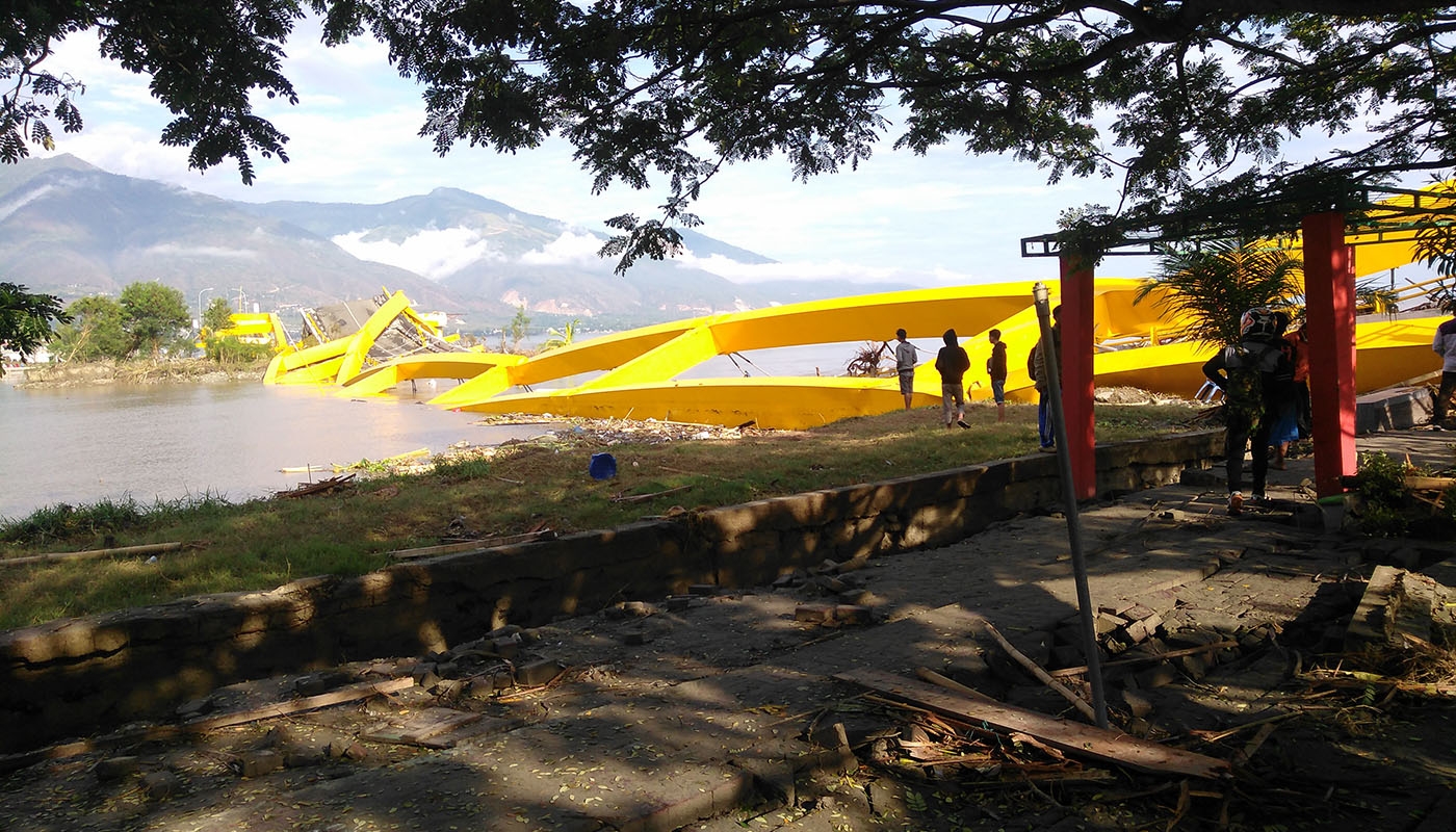 men survey a collapsed bridge in Asia-Pacific