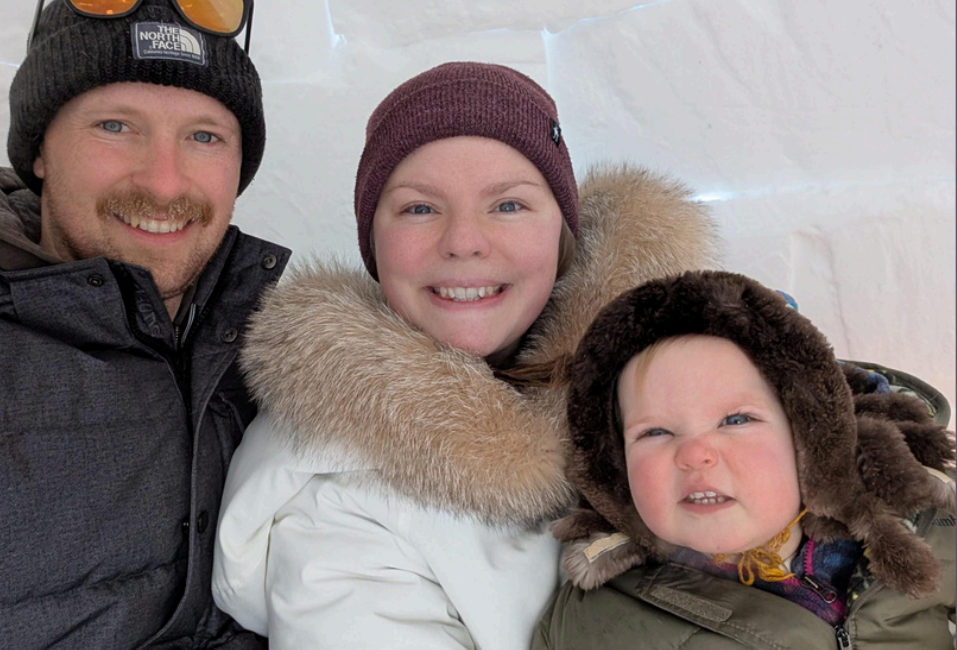 Gideon, Cassidy and their daughter dressed for snow smiling at the camera