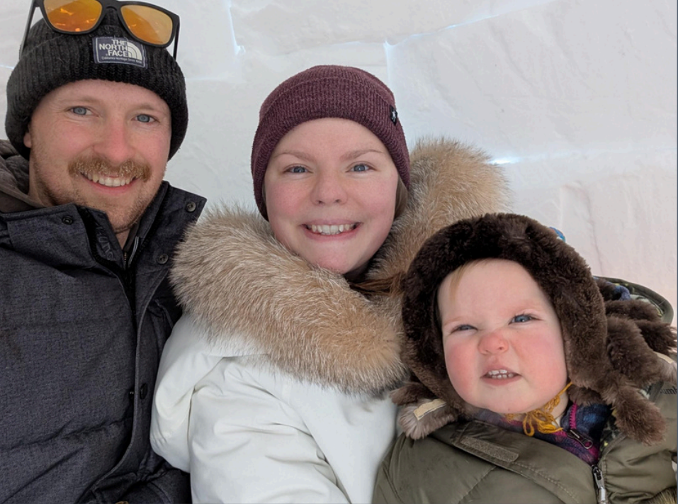 Gideon, Cassidy and their daughter dressed for snow smiling at the camera